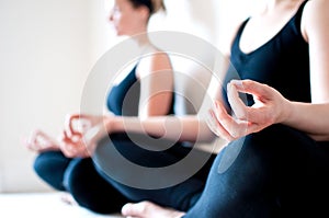 Two Girls Sit Cross Legged in a Yoga Pose