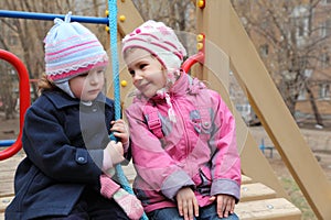 Two girls sit on playground