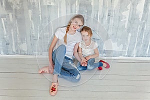 Two girls sitting at the gray wall