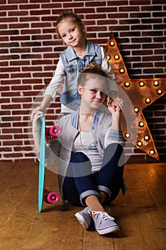 Two girls with skateboard in studio