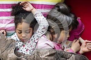 Two girls sleeping together, multi racial friendship