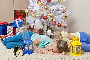 Two girls slept through the whole New Years Eve at the Christmas tree while waiting for the arrival of Santa Claus and gifts