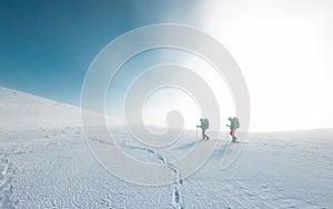 two girls in snowshoes walk in the snow. hiking in the mountains in winter