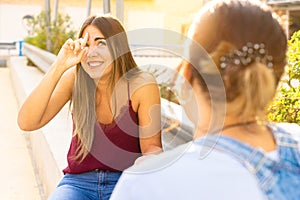 Two girls speaking in sign language in a public space. Deaf friends or couple communicating, having fun, pleasant conversation,