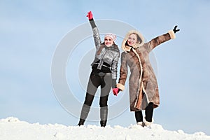 Two girls stand alongside hold on hands