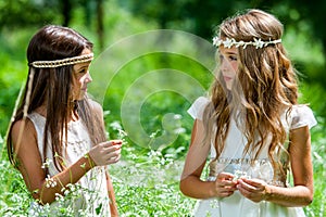 Two girls standing in flower field.