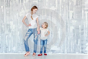 Two girls standing at the gray wall