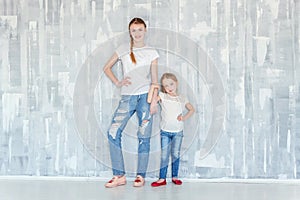 Two girls standing at the gray wall