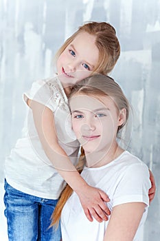 Two girls standing at the gray wall