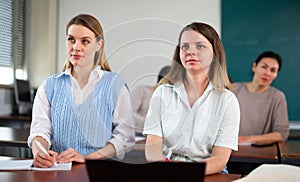 Two girls students are engaged on a laptop and writing synopsis