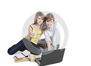 Two girls-students work on the laptop.