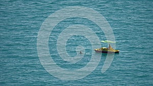 Two girls are swimming in the sea on a catamaran. Two girls in the ocean on vacation. Open sea swimming