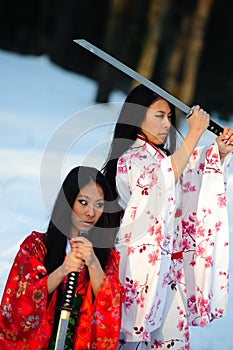 Two girls about a sword in hands