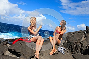 two girls taking photo on the beach in summer holidays and vacation