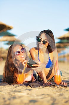Two girls taking selfy on a beach