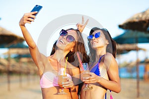 Two girls taking selfy on a beach