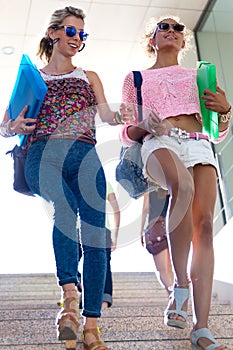 Two girls talking and laughing in the stairs.