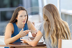 Two girls talking seriously in a coffee shop