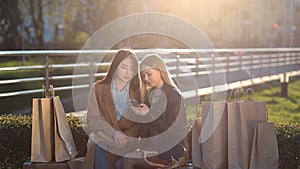 Two girls texting with friends in social network