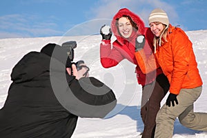 Two girls throw snows into photographer