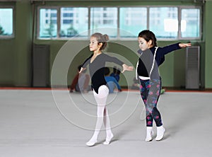 Two girls train rhythmic gymnastics