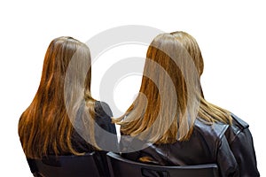 Two girls twins in auditory during presentation or seminar. Isolated background. Teenagers or young women at university lecture or