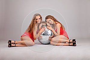 Two girls twins with glitterball on grey