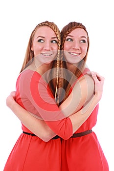 Two girls twins in red dresses hugging