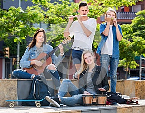 Two girls and two boys with musical instruments