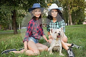 Two girls walking with his dog. cowboy hat and