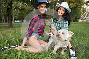 Two girls walking with his dog. cowboy hat and plaid shirt