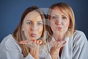 Two girls wearing bathrobe in spa or hotel having fun