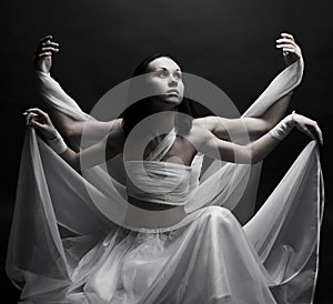 Two girls in white raiment dancing in semidarkness