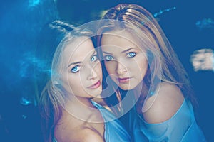 Two girls, women models in blue. Twins in the forest