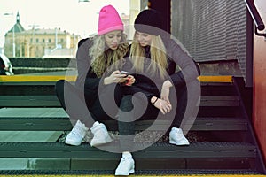 Two girls are writing sms on mobile