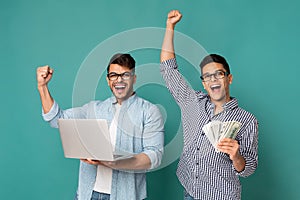 Two Gladful Men Holding Money And Laptop Rejoicing Success