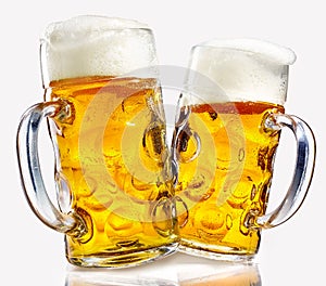 Two glass beer mugs full of golden lager