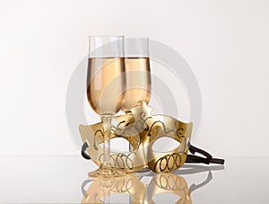 Two glass with champagne on a table with Masquerade mask