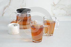 Two glass cup and teapot with tea