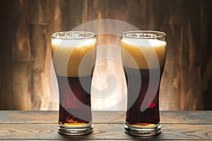 Two glass with dark beer and foam