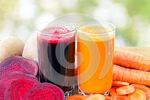 Two glass of fresh beet and carrot juice, beetroot and carrots vegetable on wooden table, defocused, nature background.
