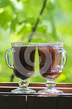 Two glass of Irish coffee on beautiful green natural background.