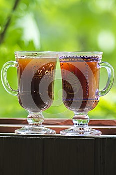 Two glass of Irish coffee on beautiful green natural background.