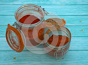 Two jars of pimenton on turquoise wooden table. photo