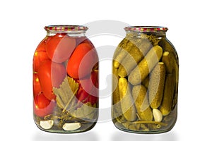 Two glass jars with tomatoes and cucumbers isolated on a white background