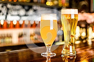 A two Glass of light beer on a pub with bokeh background