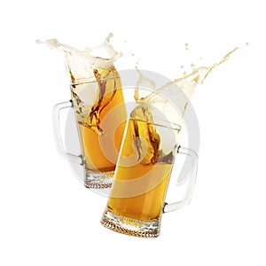 Two glass mugs of beer toasting with splash on white background