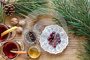 Two glass of mulled wine with cinnamon sticks, slice of oranges and apple, star anise on a wooden table