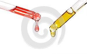 Two glass pipettes with colored oils that