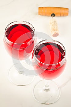 Two glass of red wine and corkscrew on white background/Two glass of red wine and corkscrew on white background. Top view